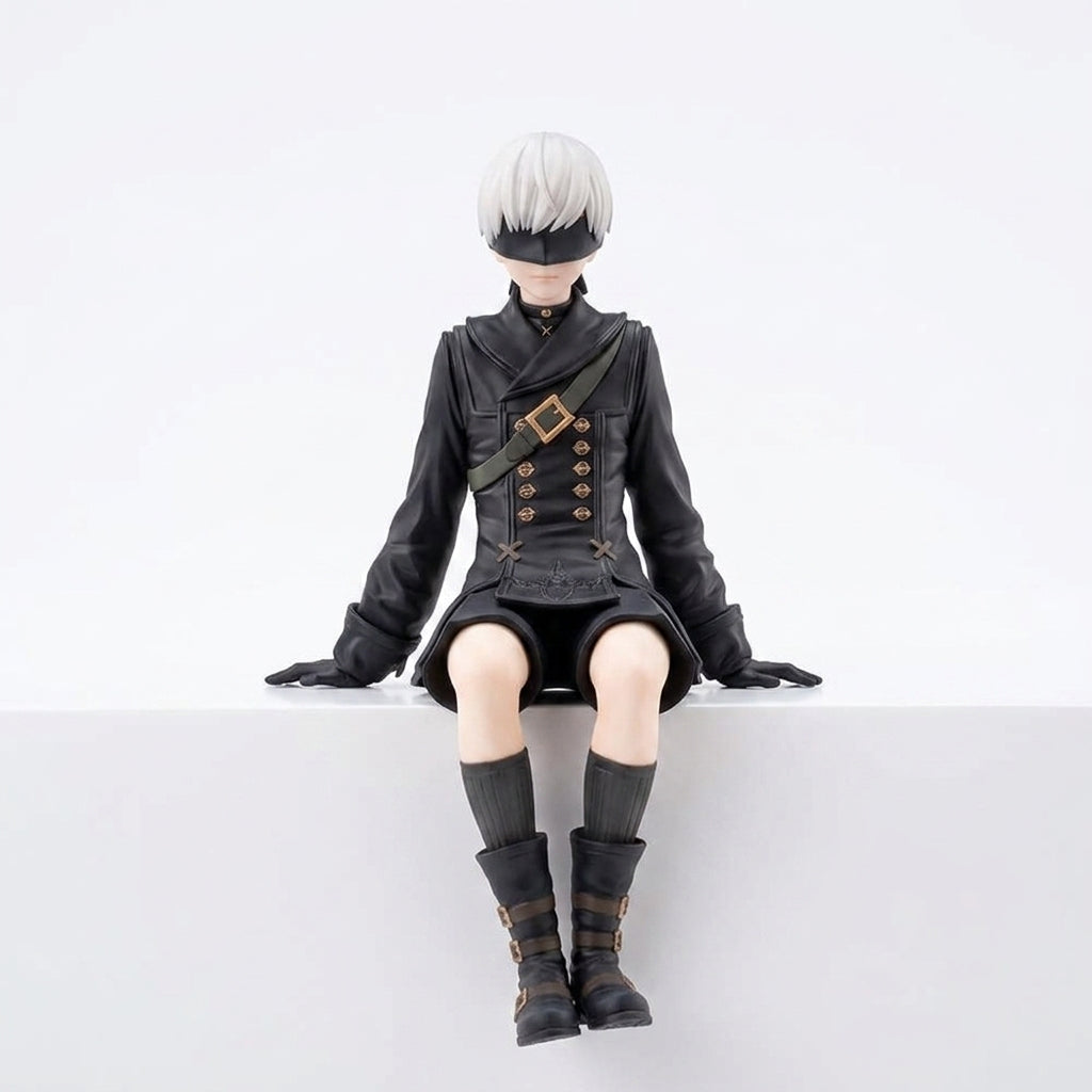9S inspired PVC collectible figure front view seated pose showing detailed black YoRHa uniform with shoulder strap gold buttons white hair and black blindfold on white background