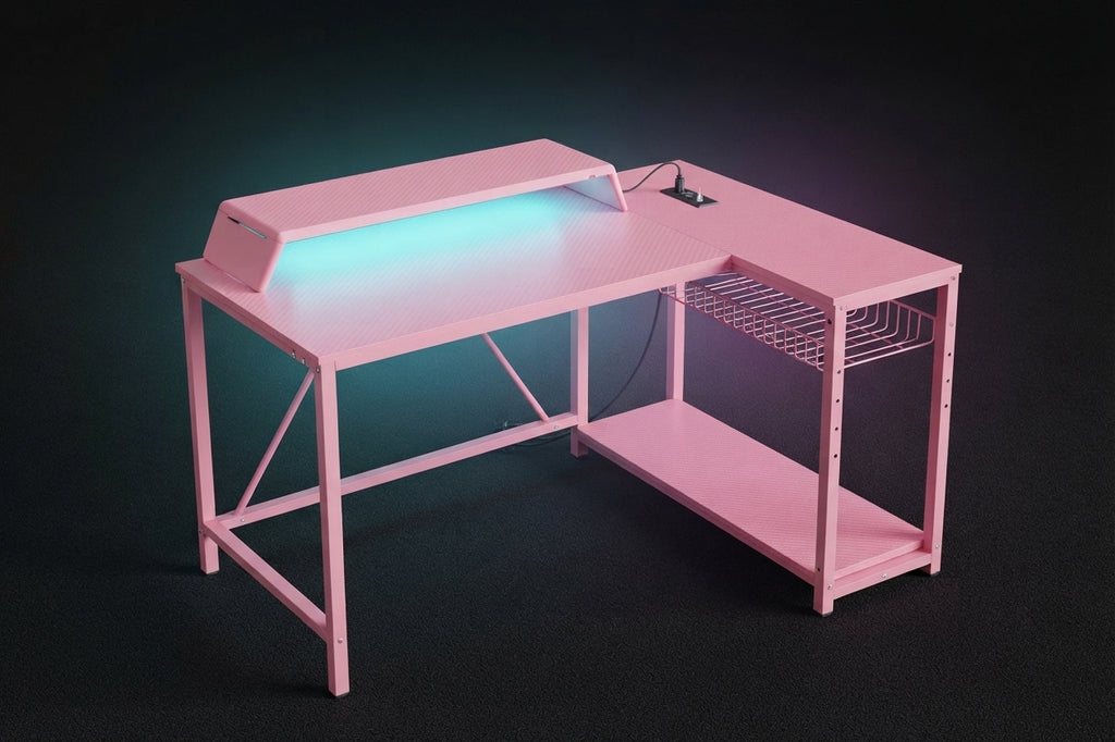 Pink L-shaped gaming desk with teal RGB underglow lighting monitor riser wire shelf and built-in power strip on dark background